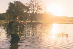 wędkarz na tle zachodzącego słońca